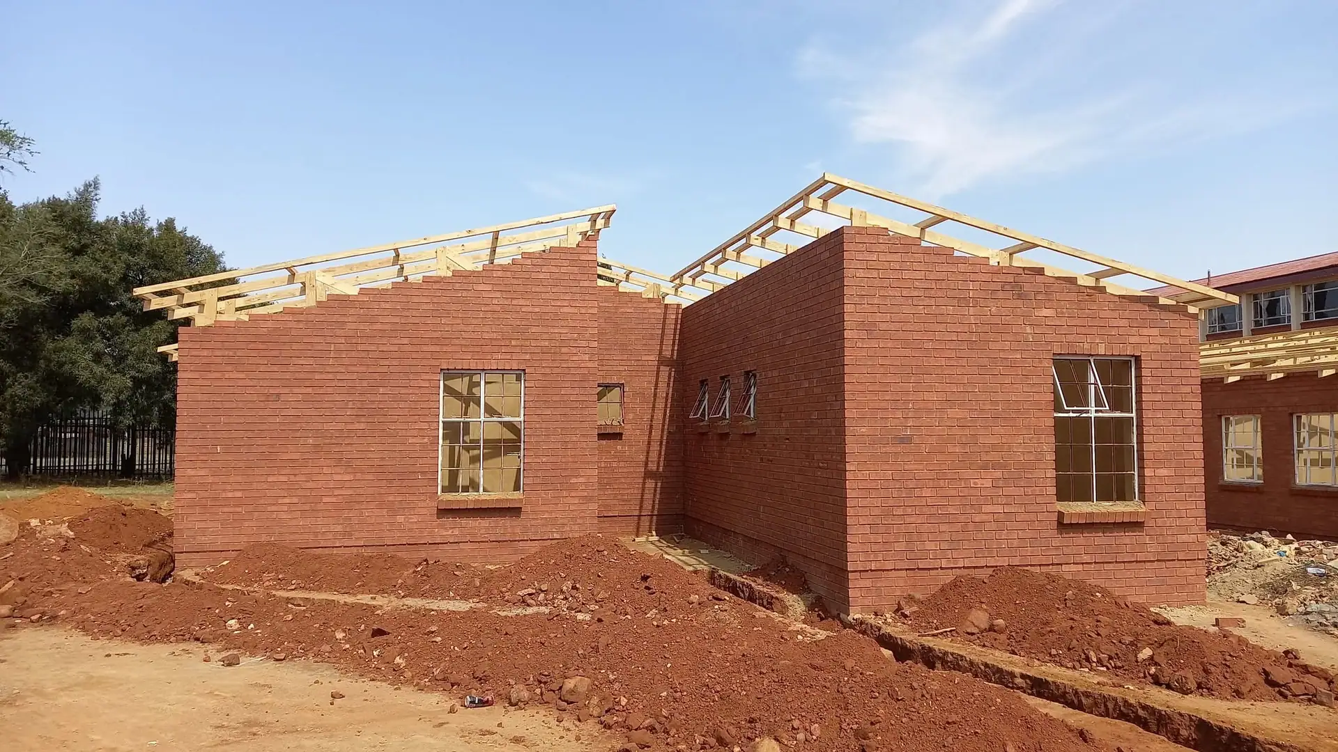Brick house under construction with the roof trusses going up