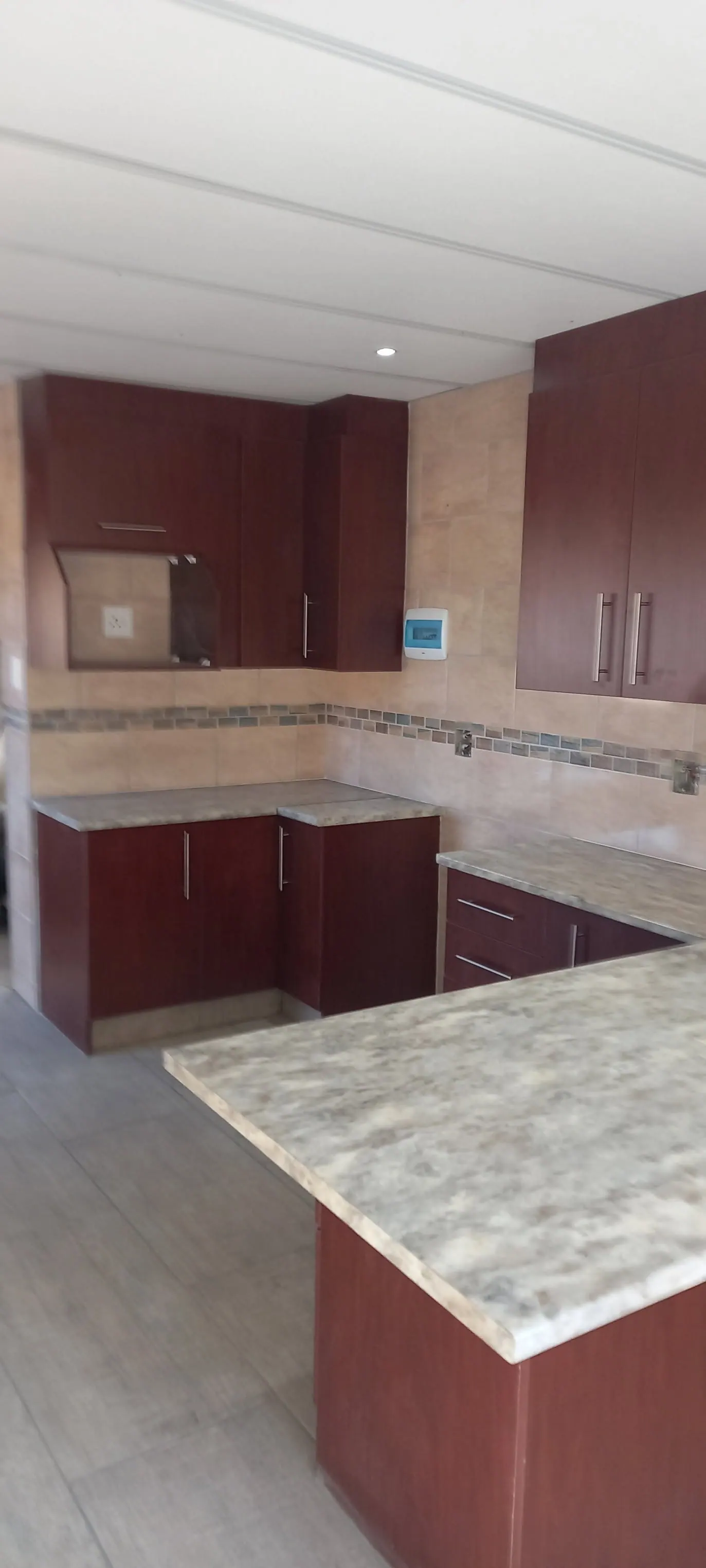 Finished kitchen with granite tops and maroon cabinets