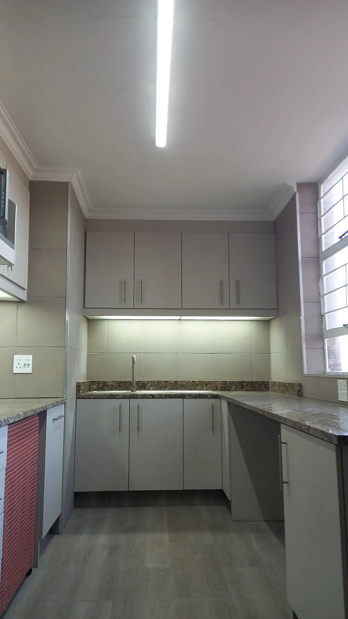 Kitchen with grey cabinets and under-cabinet lighting